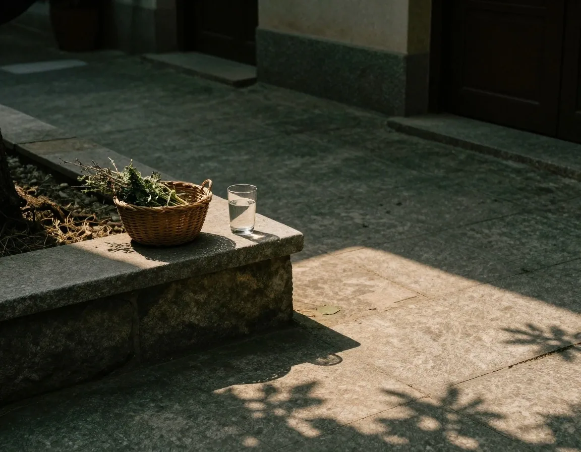 A shaded bench in a residential courtyard with a folded towel and small dish resting on it